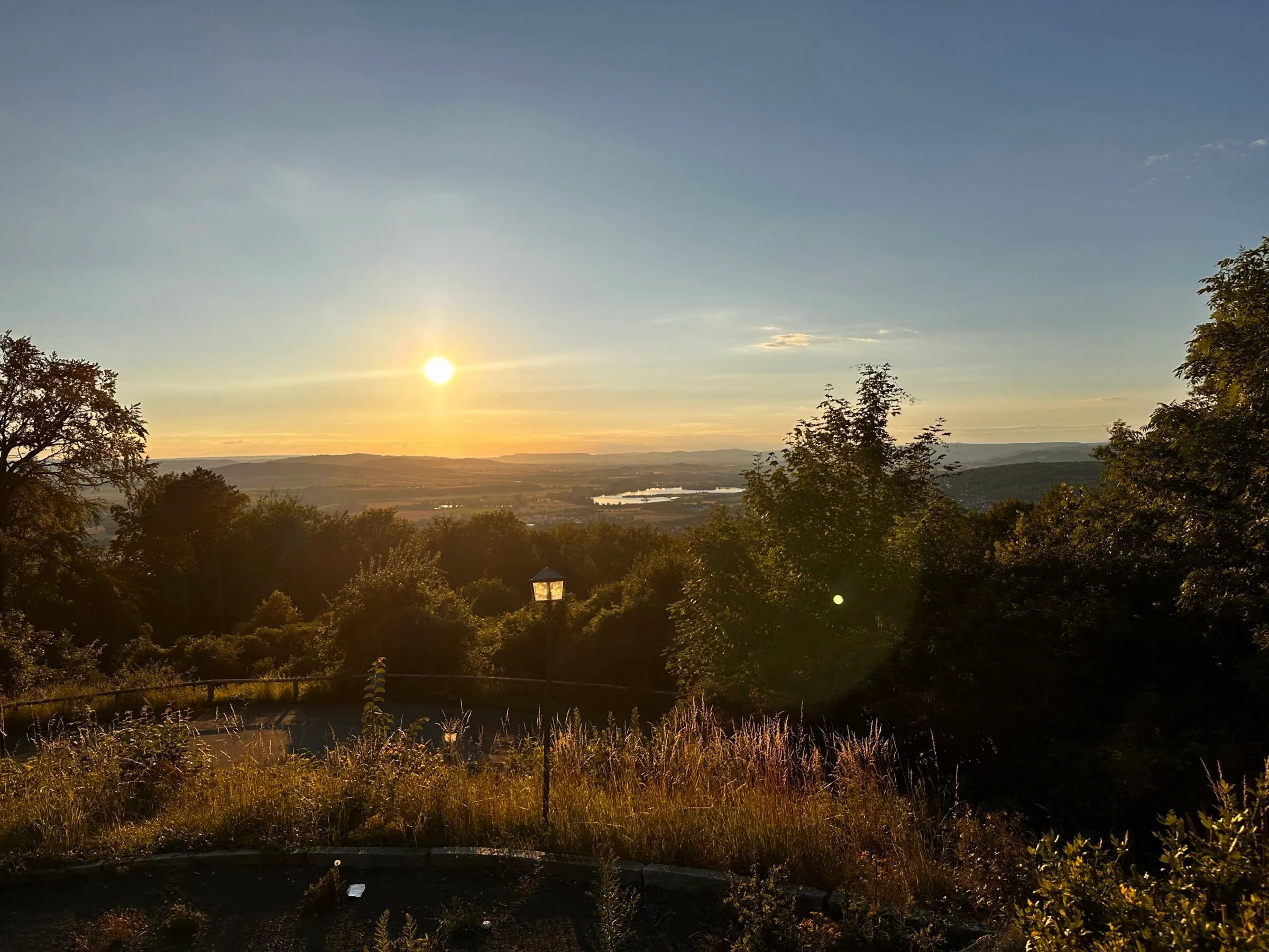 Goldener Sonnenuntergang über den Hügeln und Kiesseen bei Northeim, gesehen vom Ausblick am Wieterturm