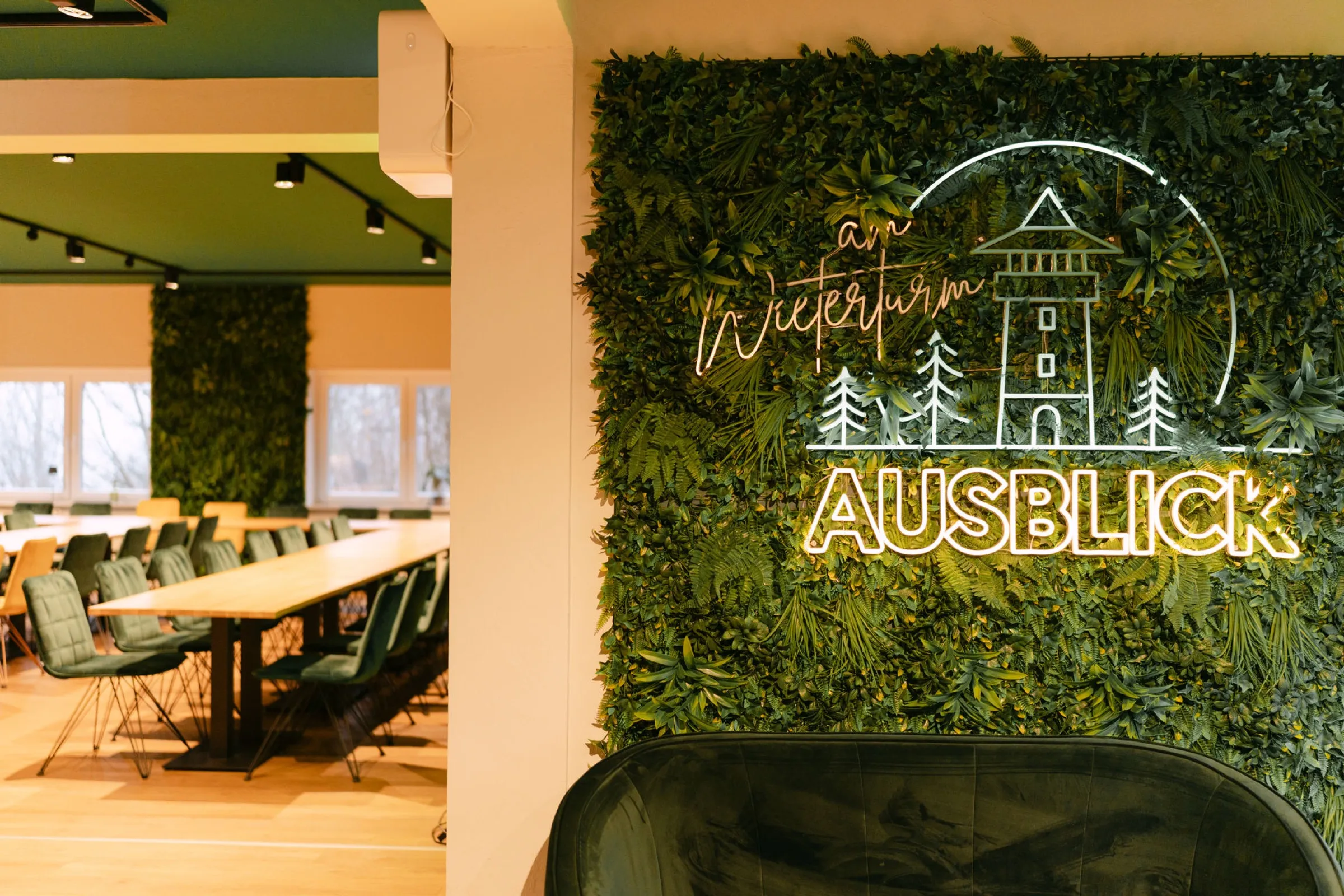 Tagungsraum mit flexibler Bestuhlung und Neon-Mooswand im Ausblick am Wieterturm